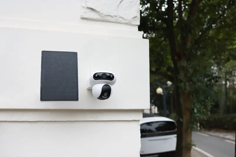 HB90x Dual con panel solar montada en una fachada, mirando a la calle